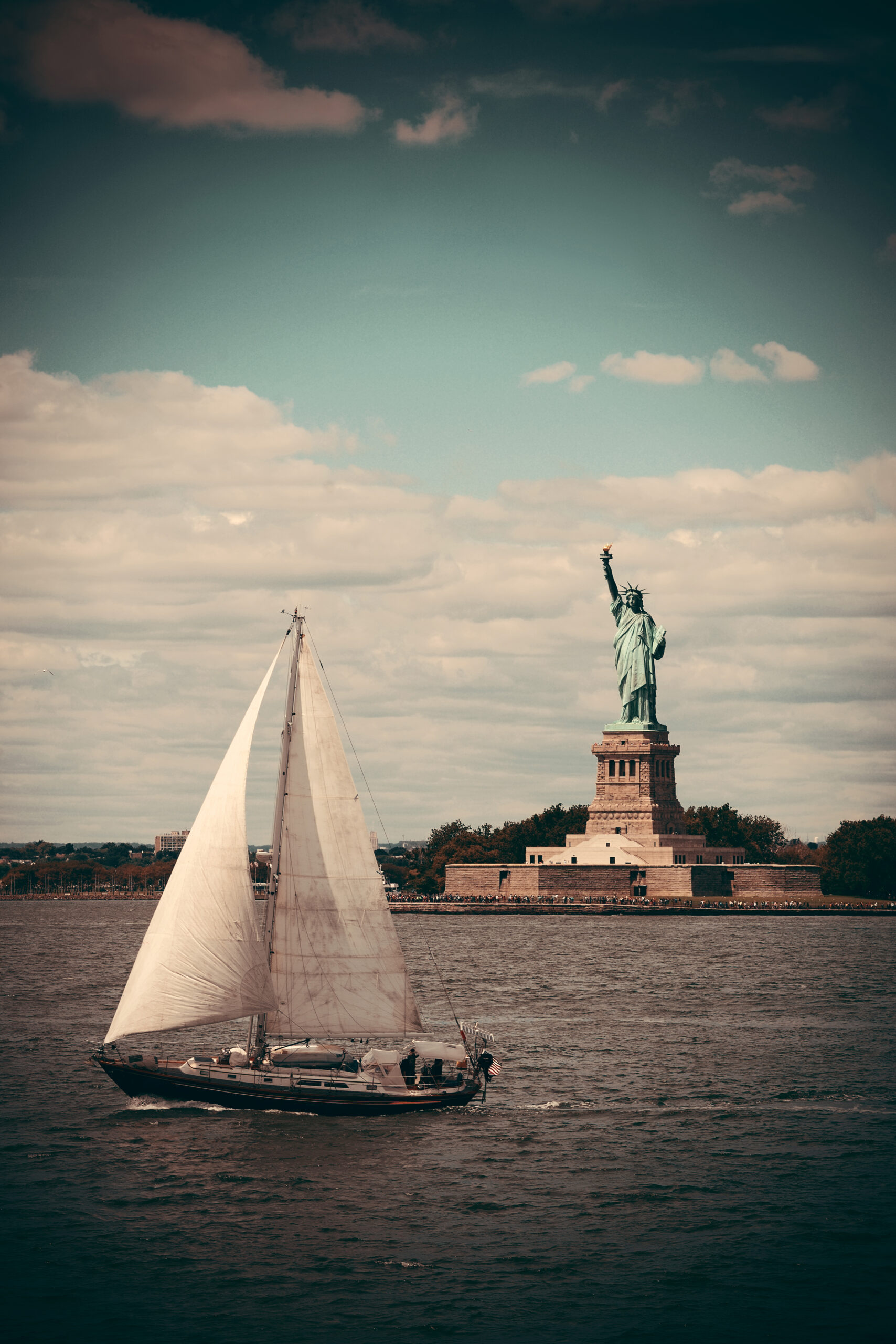 statue liberty new york city harbor with sailing boat scaled